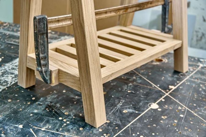 Gros plan sur le pied de meuble en bois en cours d'assemblage dans un atelier de menuiserie